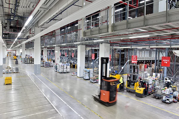 Kommissonierfahrzeuge stehen in einer Lagerhalle für Lebensmittel.