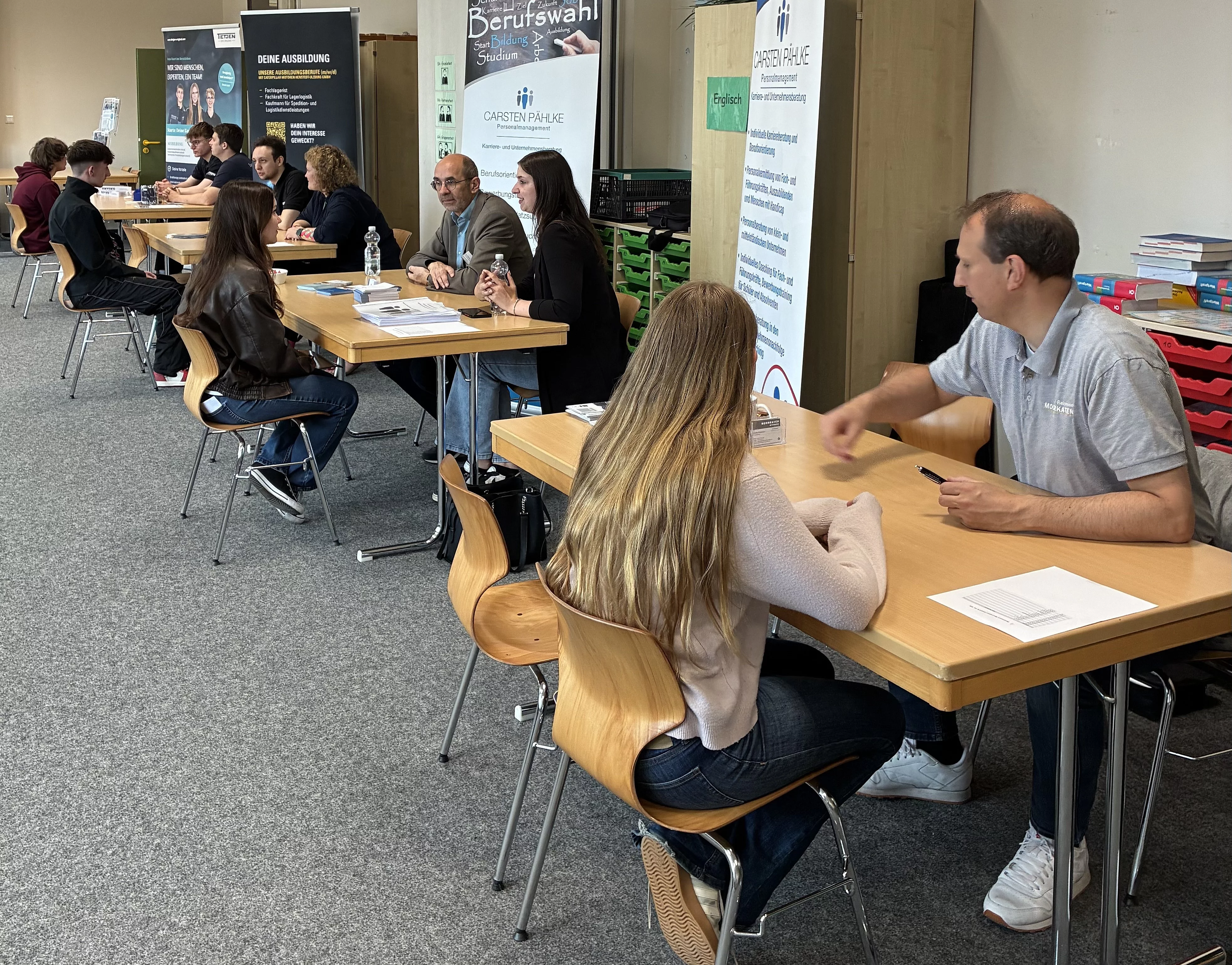 Schülerinnen und Schüler und Unternehmen tauschen sich beim Azubi-Speed-Dating zu Ausbildungsmöglichkeiten aus und lernen sich kennen.